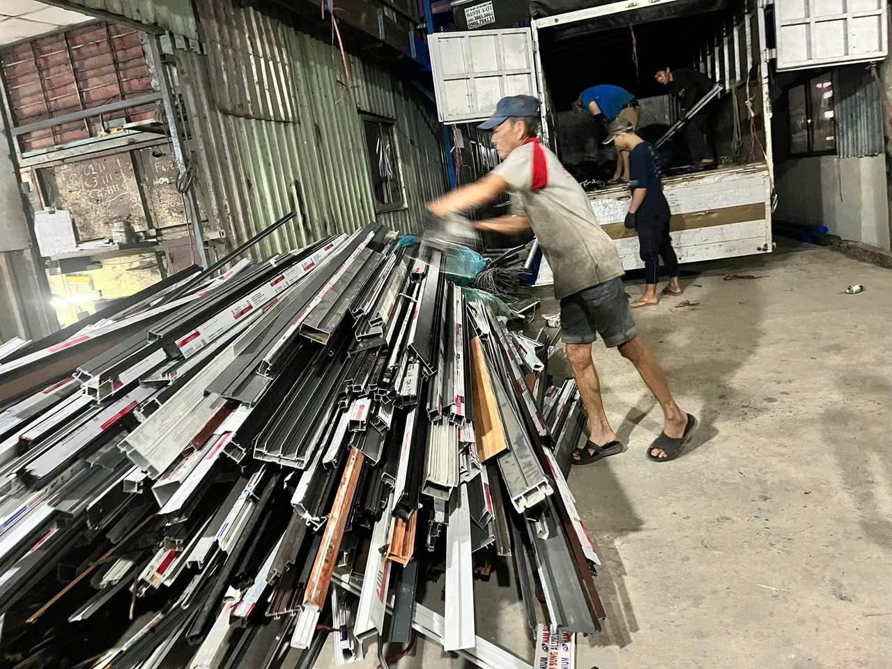 công nhân đang thu gom nhôm và các loại phế liệu lên xe